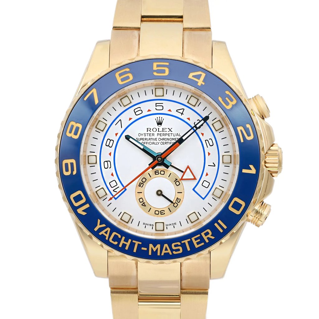 An image of a pre-owned wristwatch, captured in a front close-up shot. The watch face is prominently displayed, featuring a gold case and a blue bezel with yellow numerals. The dial includes multiple hands and a subdial, with detailed markings and text. The gold bracelet is partially visible, complementing the luxurious design.