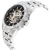 An image of a pre-owned Bulova men's wristwatch in a side profile view, highlighting its crown. The watch features a skeleton dial with a black background, luminous hands, and a round stainless steel case. The bezel is also made of steel, and the watch is equipped with a stainless steel band. The skeleton dial allows a view into the watch's internal workings, and the timepiece exudes a sporty yet elegant style. The photo is taken at a close distance, emphasizing the watch's side angle to showcase its depth and the detailing of the crown and case.