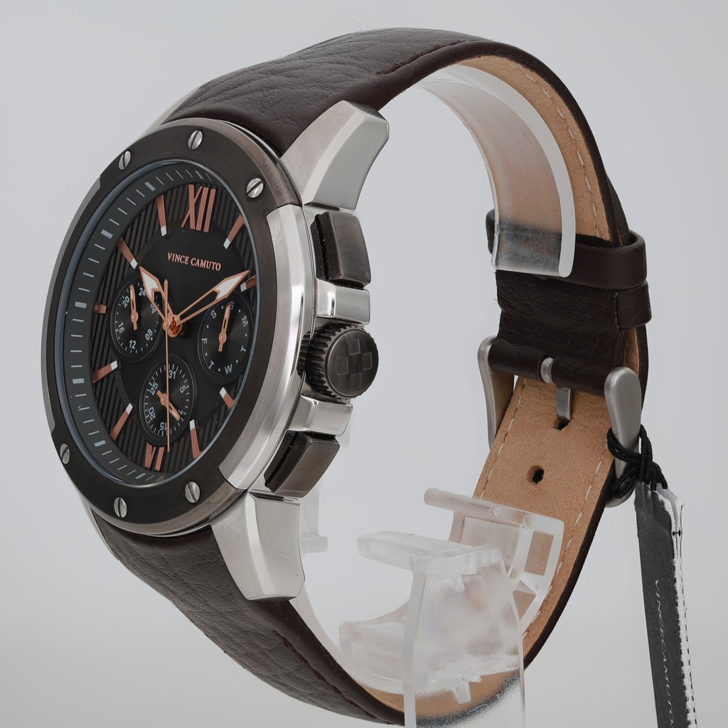 An image of a Wristwatch by Vince Camuto. This Display Model item is designed for Men, featuring a Casual style. It has a Quartz movement and an Analog display with a Gray dial color. The indices include 12-Hour Dial,Non-Numeric Hour Marks. The band is made of Leather and the case is made of Stainless Steel. The watch has a Round shape with a case size of 46.5 mm and a case thickness of 13 mm.