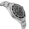 An image of a pre-owned men's luxury Rolex wristwatch viewed from the side profile opposite the crown. The watch has a round shape with a black dial and black bezel. It features a stainless steel band and case, and is equipped with a date indicator and luminous hands. The watch is in good condition.