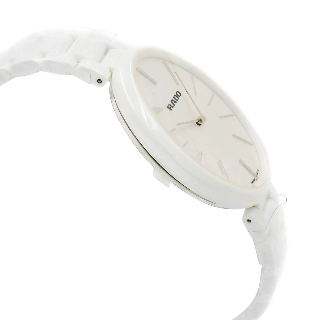 An image of a wristwatch shown from the side profile, opposite the crown. The watch is a display model, featuring a sleek, white design with a matching white bracelet. The angle captures the watch face slightly tilted, emphasizing its thin case and minimalist dial. The photograph is taken at a close distance, highlighting the smooth, polished finish of the watch.