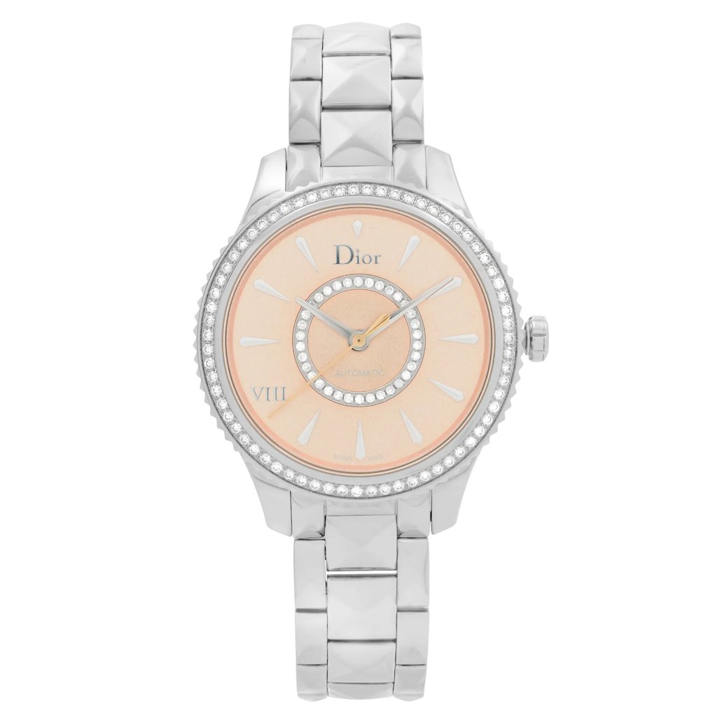 An image of a Dior women's dress wristwatch in excellent condition, displayed in a full frontal view. The watch features a round, stainless steel case and band, with a pink dial. The dial is accented with elegant markings, and the overall style is formal, suitable for dress occasions.