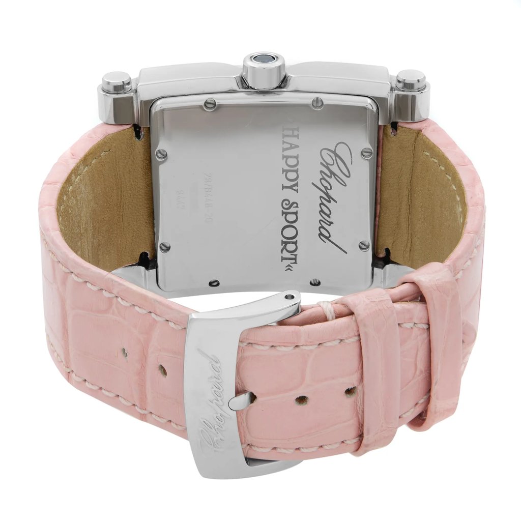 An image of a pre-owned wristwatch viewed from the back, showcasing the close clasp. The watch features a pink leather strap with visible stitching and a rectangular stainless steel case. The brand name is engraved on the case back. The angle provides a clear view of the clasp and the textured strap, photographed at a close distance.