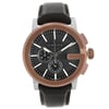 An image of a pre-owned Gucci men's wristwatch in good condition, presented in a front full frontal view. The watch features a round stainless steel case with a bronze bezel, a black teaked dial, and stick indexes. The dial includes a 12-hour display with multiple subdials, luminous hands, and a small seconds subdial. The watch is complemented by a leather band and showcases a dress/formal style. The watch is photographed up close, occupying most of the frame, allowing for clear visibility of the watch details.