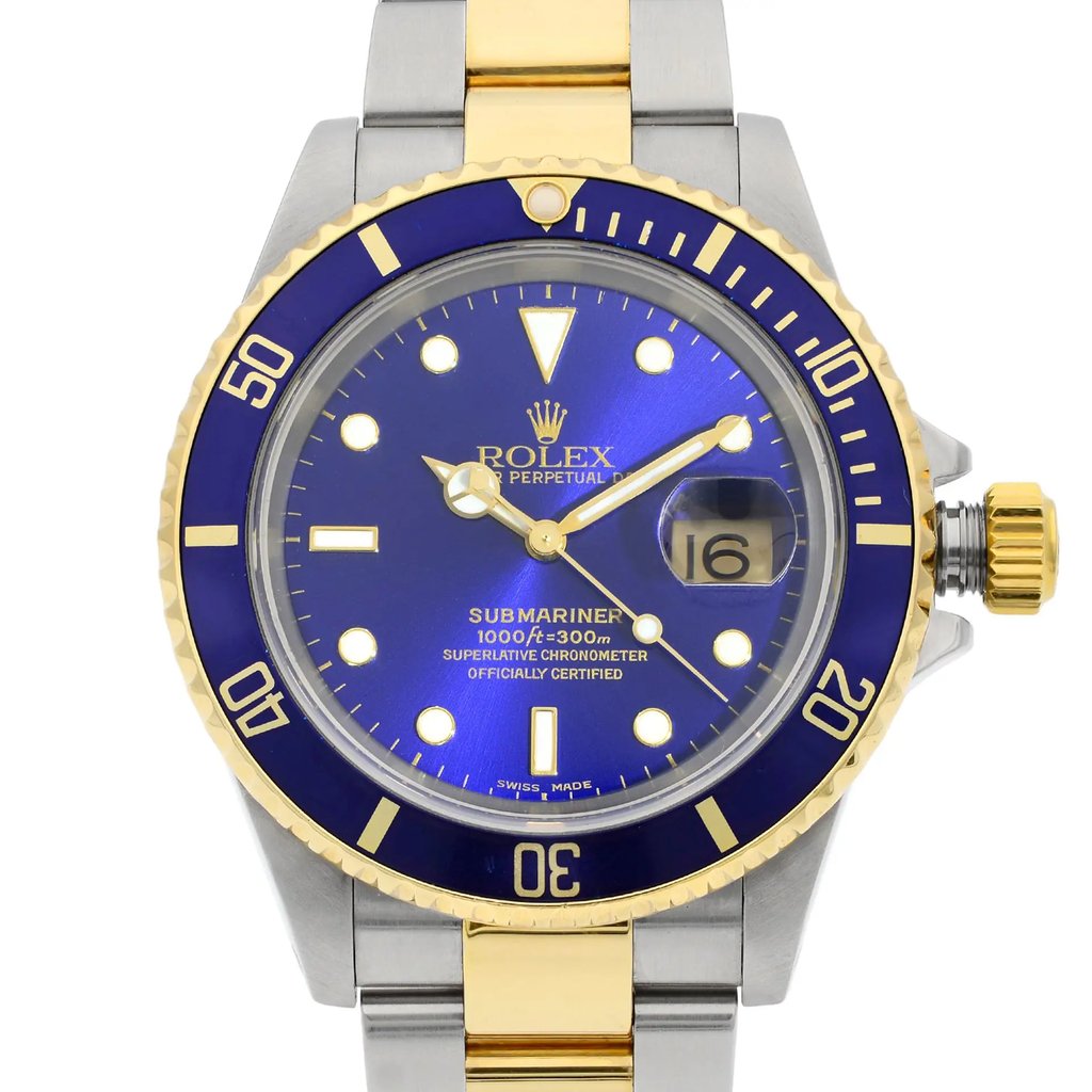 An image of a pre-owned Rolex Submariner men's wristwatch in good condition, featuring a luxurious round blue dial with luminous hands and non-numeric hour marks. The close-up front view shows the watch face at a direct angle, with the band partially visible, highlighting the stainless steel and solid gold materials. A date indicator is visible at the 3 o'clock position, and the timepiece has a prominent rotating bezel in blue with gold-tone markings, which shows minor micro-scratches indicative of previous wear. The watch is positioned centrally and shot from a close distance to capture detail.