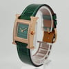An image of a pre-owned Hermès women's wristwatch displayed at a slight angle, positioned to the right. The watch features a green leather strap and a square face with a green dial. The rose gold case is adorned with sparkling stones, and the watch is mounted on a transparent stand, showcasing its elegant design from a close-up perspective.