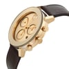 An image of a pre-owned wristwatch viewed from a side profile angle, highlighting the gold-toned case and prominently displaying the crown. The watch face features multiple subdials and gold hands, complemented by a dark leather strap. The photograph is taken from a close distance, emphasizing the watch's design and details.