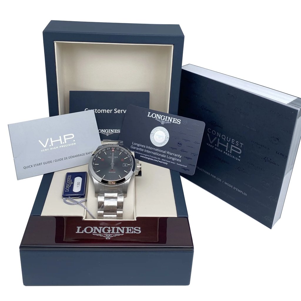 An image of a display model wristwatch positioned centrally within an open box. The watch is upright, showcasing its face and metal band. Surrounding the watch are documents, including a warranty card and a quick start guide, neatly arranged. The angle is front-facing, capturing a full view of the watch and its accompanying items, with a close distance to highlight details. The box and documents are branded, adding to the presentation.