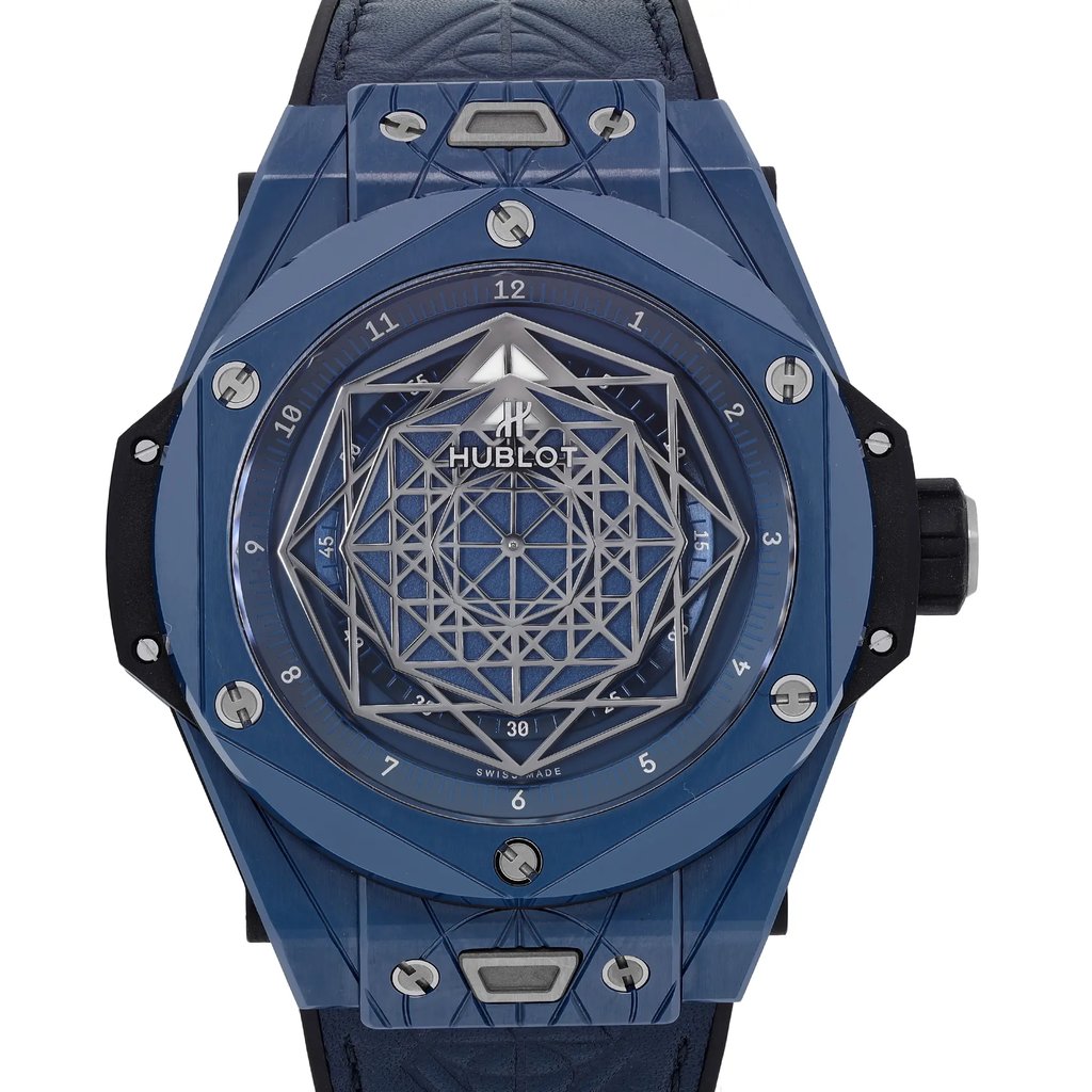 An image of a pre-owned wristwatch, featuring a close-up, front view of the watch face. The watch has a geometric design with a blue color scheme and visible screws around the bezel. The intricate dial includes a lattice pattern, and the brand name is visible at the center. The angle is straight-on, capturing the details of the watch's design elements.