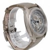 An image of a pre-owned men's Vacheron Constantin wristwatch, taken from a three-quarter angle, slightly above and to the left. The watch features a metallic case and a leather strap. The face displays luminous hands and intricate detailing. The angle highlights the side profile and the depth of the watch, with the strap partially open. The image is taken at a close distance, showcasing the craftsmanship and details of the timepiece.