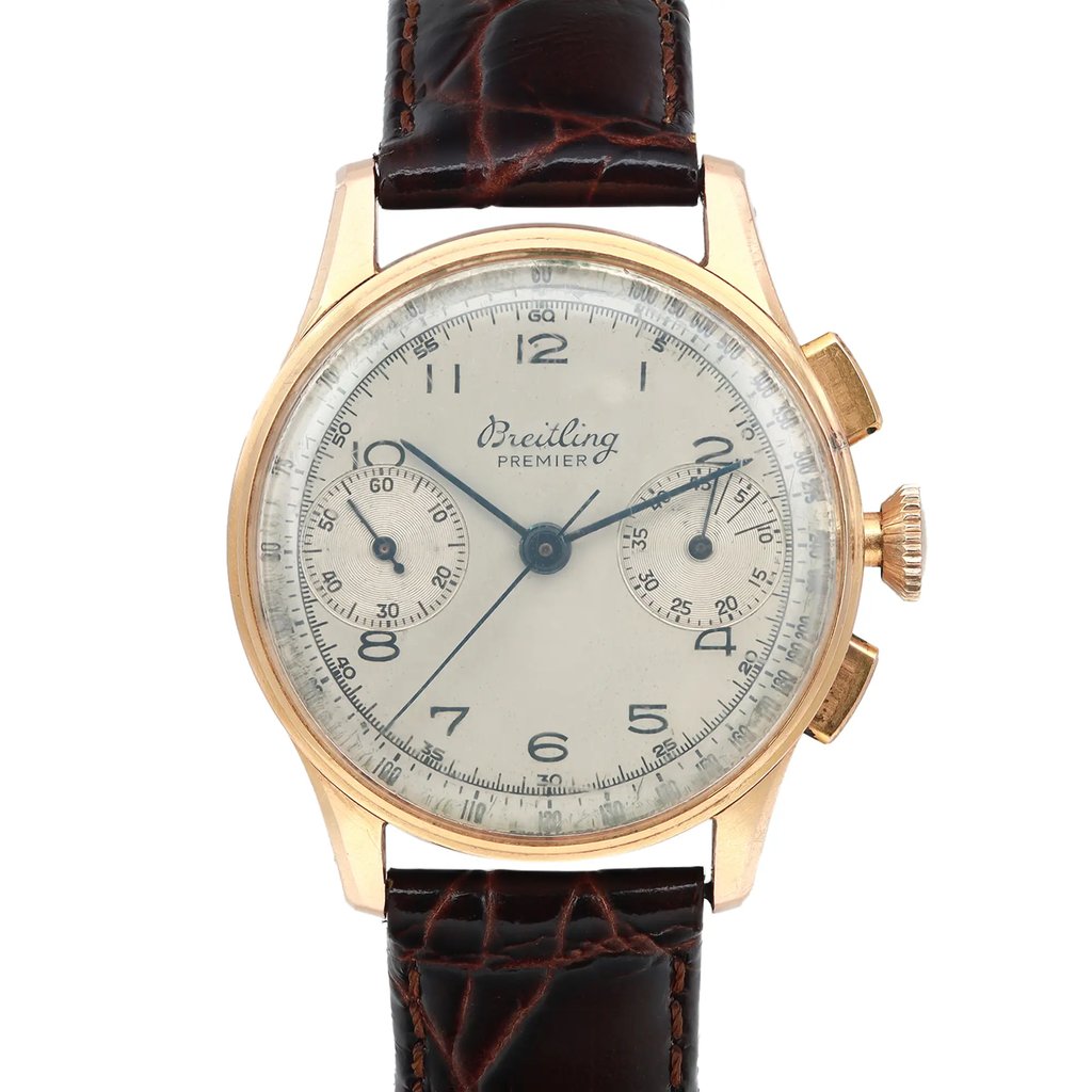 An image of a pre-owned Breitling men's wristwatch in fair condition, with a classic style. The front close-up shot shows the watch face at a direct angle with a clear view of the silver dial that has developed a patina and the rose gold bezel and case. It features a round shape, Arabic numerals, and a small seconds subdial. The watch is paired with an aftermarket dark brown leather band. The image is taken from a medium distance, providing a detailed view of the watch's features.