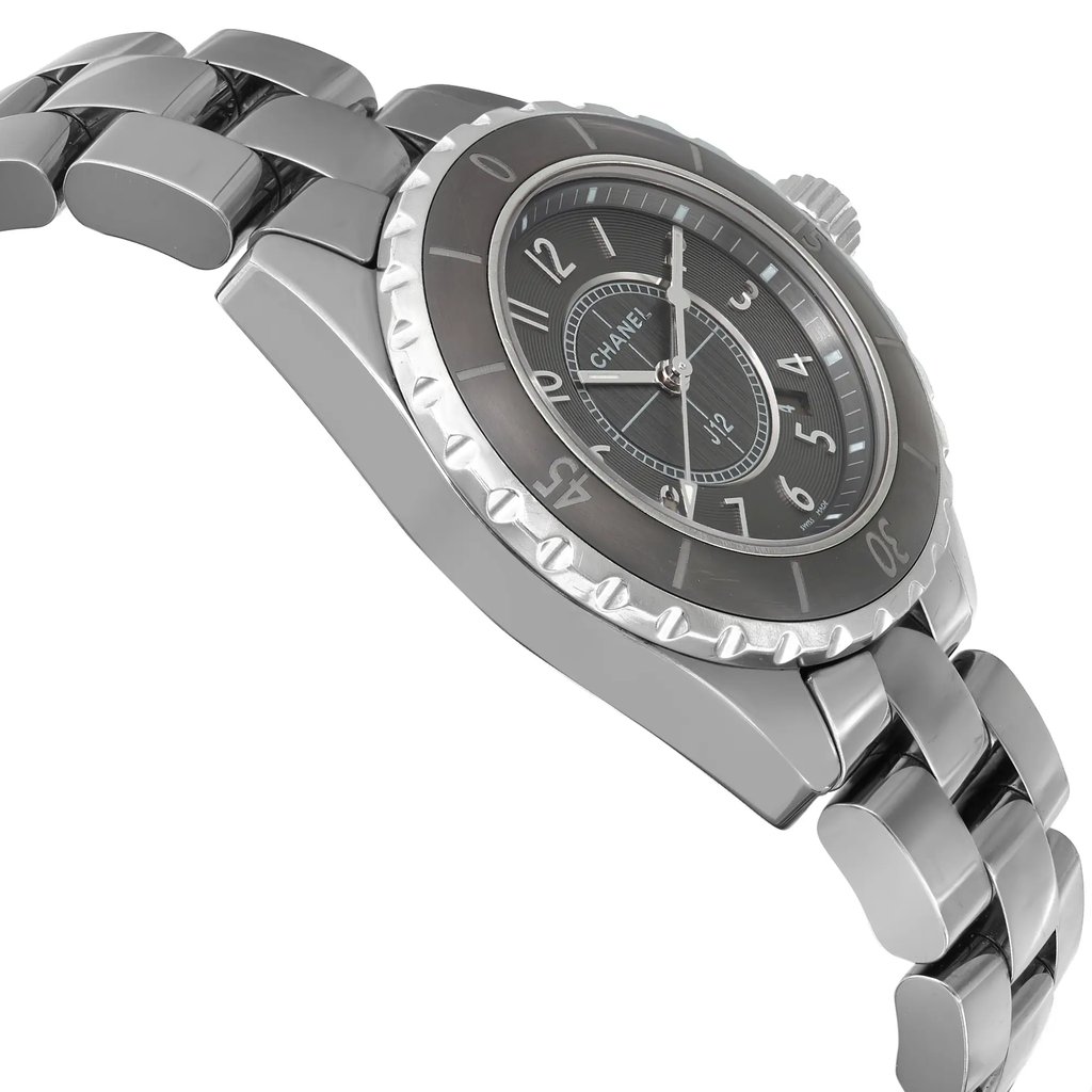 An image of a pre-owned CHANEL wristwatch in a side profile view, opposite of the crown. The watch features a round shape and a casual style, with a gray dial and bezel. It has a ceramic band and case, and includes a date indicator and luminous hands. The watch is angled to show the side profile and is photographed up close to highlight its design details.