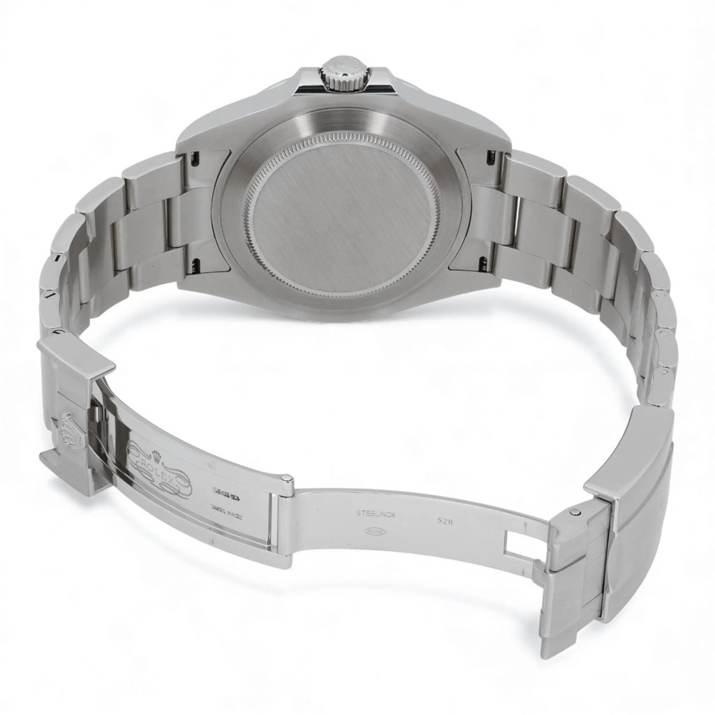 An image of a pre-owned men's Rolex wristwatch, viewed from the back at a slight angle. The focus is on the stainless steel case and bracelet, with the watch positioned horizontally. The watch clasp is open, revealing the Rolex engraving on the inside. The date indicator and luminous hands are not visible in this view. The image is taken at a close distance to highlight the details of the watch's construction.