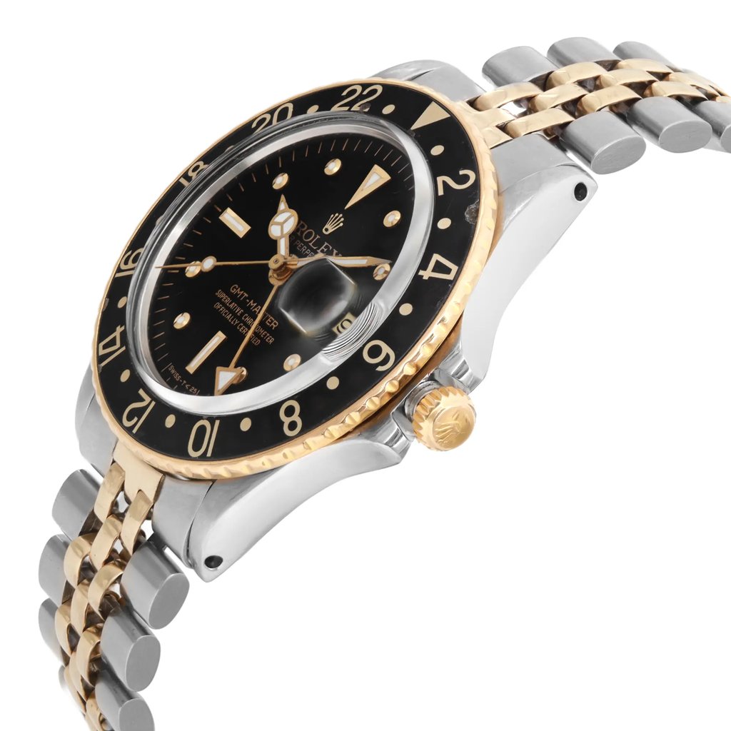 An image of a pre-owned wristwatch shown from a side profile view. The gold crown is prominently visible on the right side. The watch features a black dial with gold accents and a two-tone metal bracelet. The angle highlights the watch's thickness and the curvature of the bracelet, captured from a moderate distance.