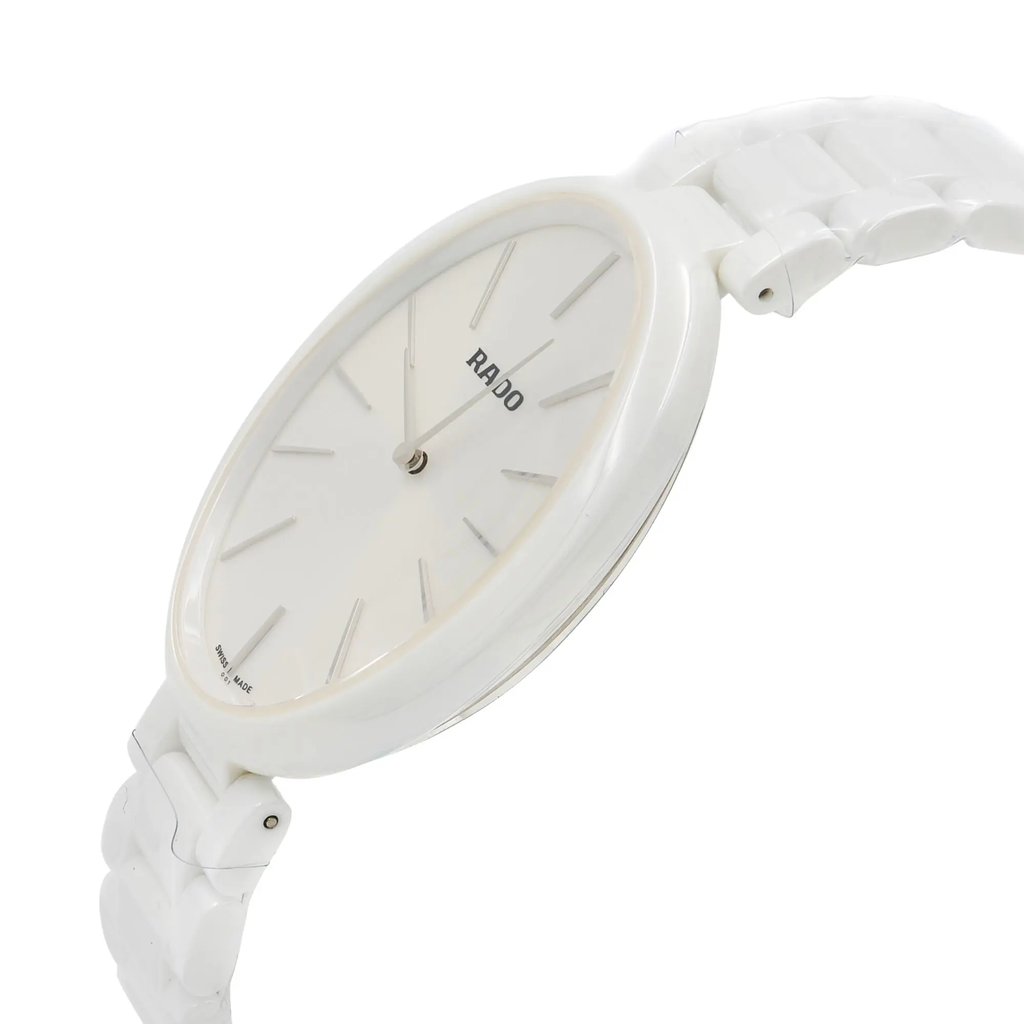 An image of a wristwatch in a side profile view, showcasing the crown. The watch features a sleek design with a white case and matching band. The face displays minimalist hour markers and hands. The angle highlights the watch's thin profile, emphasizing its elegant and modern design. The focus is on the watch's side, providing a detailed look at its contours and craftsmanship.