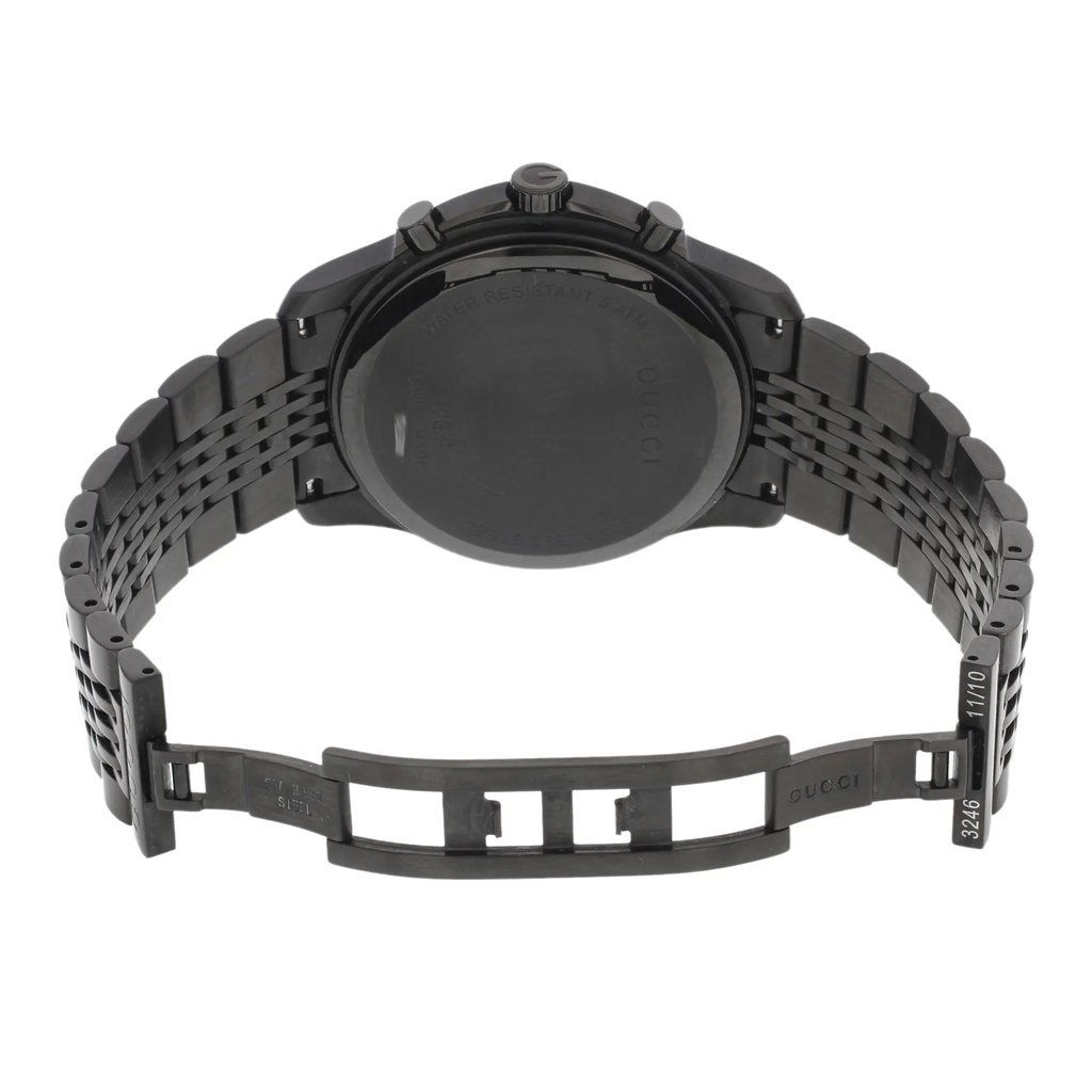 An image of a pre-owned Gucci men's wristwatch in stainless steel, showcasing the back view with an open double-locking fold-over clasp. The round caseback has a snap closure and is engraved with the brand name and water resistance information. The stainless steel band is partially extended and the watch is photographed from a top-down angle, providing a clear view of the entire backside of the watch. The watch is positioned centrally within the frame and occupies most of the image space, with a slight distance allowing the entire watch to be in focus.