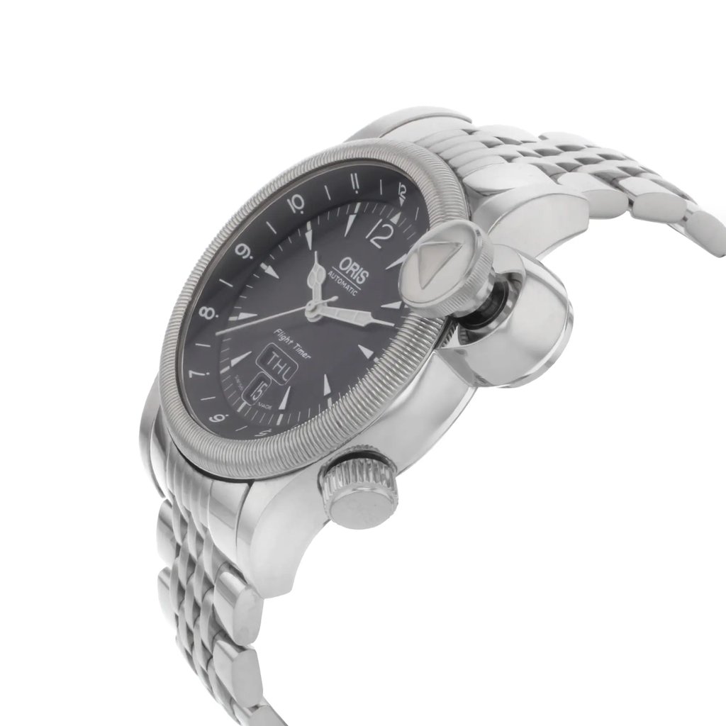 An image of a pre-owned wristwatch viewed from the side profile, highlighting the prominent crown. The angle showcases the watch's face and metallic band from a slightly elevated perspective, focusing on details of the crown and bezel. The watch is positioned at a close range, capturing the texture and shine of the metal.