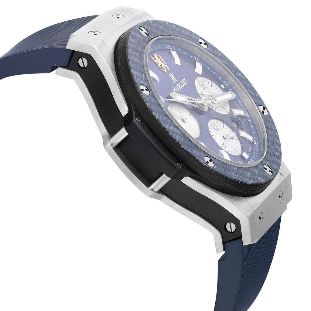 An image of a pre-owned wristwatch taken from a side profile view opposite the crown. The watch features a blue strap and a large, round face with a blue bezel. The angle highlights the watch's thickness and detailed craftsmanship, while the distance provides a clear view of the watch's side design and materials.