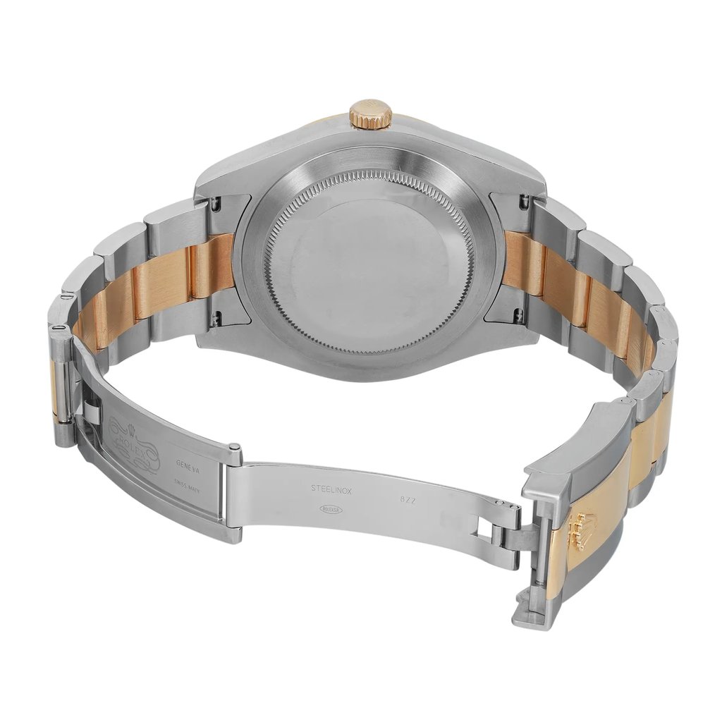 An image of a pre-owned Rolex men's wristwatch viewed from the back, showing an open fold-over clasp. The watch is positioned at a slight angle with the top of the watch facing slightly to the left. The stainless steel screwback case is visible with the brand's name inscribed, alongside a round case shape. The band is made of stainless steel with solid gold center links, showing light signs of wear. The watch is photographed from a close distance, providing a clear view of the watch's construction and condition.