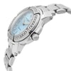 An image of a pre-owned wristwatch captured from a side profile view. The focus is on the crown, prominently displayed on the right side of the watch case. The watch has a silver metal bracelet and a bezel adorned with small stones. The dial appears to be light blue, and the watch is photographed at a close distance, highlighting its details and craftsmanship.