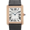 An image of a pre-owned Cartier luxury wristwatch for women, presented in a front close-up view highlighting the watch face. The watch features a silver dial, Roman numeral indices, and blue hands, enclosed in a rose gold rectangular case with minor signs of wear. The bezel is also rose gold, and it is attached to a black leather band. The watch is positioned straight on at a close distance, offering a clear view of the dial and Cartier branding.