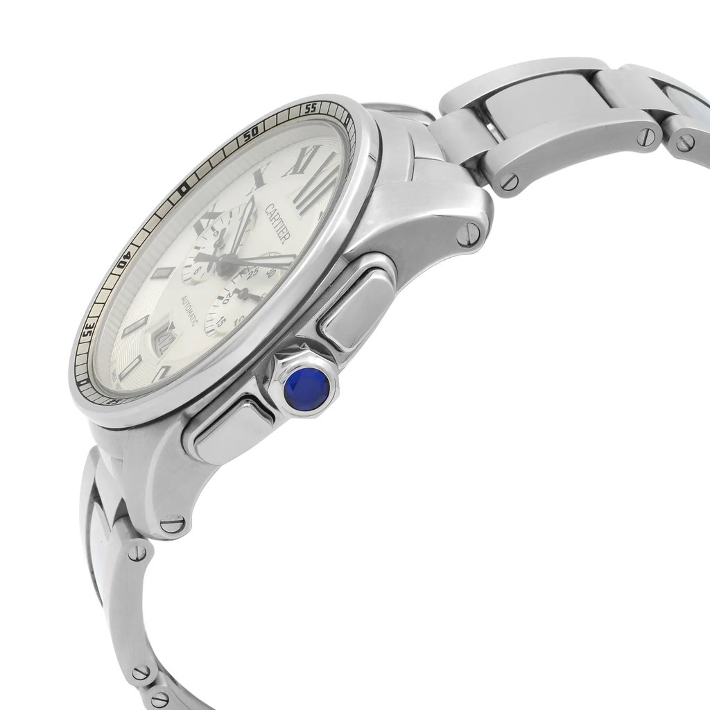 An image of a pre-owned Cartier men's luxury wristwatch, presented in a side profile view that highlights the crown. The watch features a round stainless steel case with a silver dial, viewed from a close distance and angled to showcase the watch's side, including a blue cabochon crown and the stainless steel band's link construction.