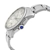 An image of a pre-owned Cartier men's luxury wristwatch, presented in a side profile view that highlights the crown. The watch features a round stainless steel case with a silver dial, viewed from a close distance and angled to showcase the watch's side, including a blue cabochon crown and the stainless steel band's link construction.