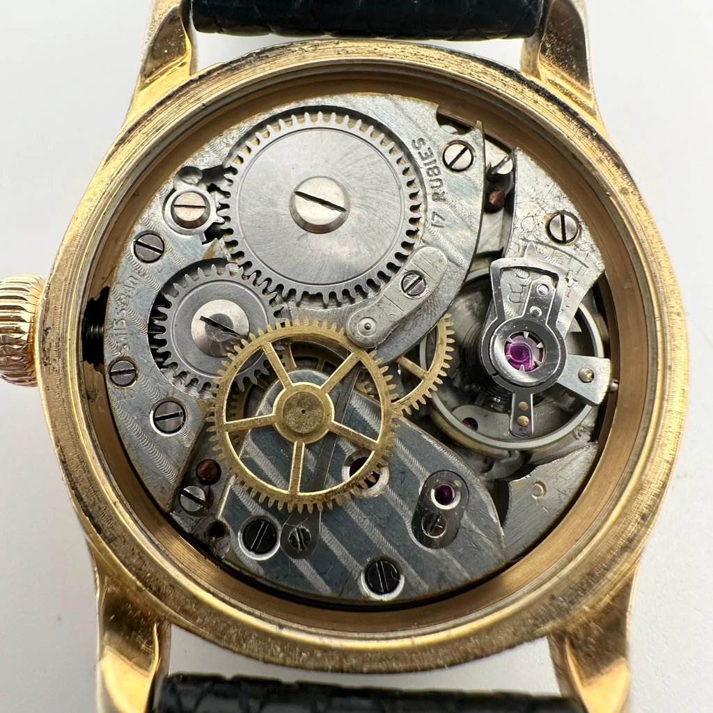 An image of a Wristwatch by Rolex. This Pre Owned item is designed for Women, featuring a Classic style. It has a Mechanical (Manual) movement and an Analog display with a Black dial color. The indices include 12-Hour Dial,Arabic Numerals,Arrow Markers. The band is made of Leather and the case is made of Stainless Steel. 
