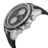 An image of an unworn Edox men's wristwatch in a dress/formal style, presented in a side profile view with the crown and pushers visible, positioned at a three-quarter angle to showcase the side details. The dial is black, and the bezel is gray, complemented by a round stainless steel case and a black rubber band. The watch features include a chronograph, day/date function, luminous hands, and a small seconds subdial. The watch is positioned close-up, providing a clear view of its details.