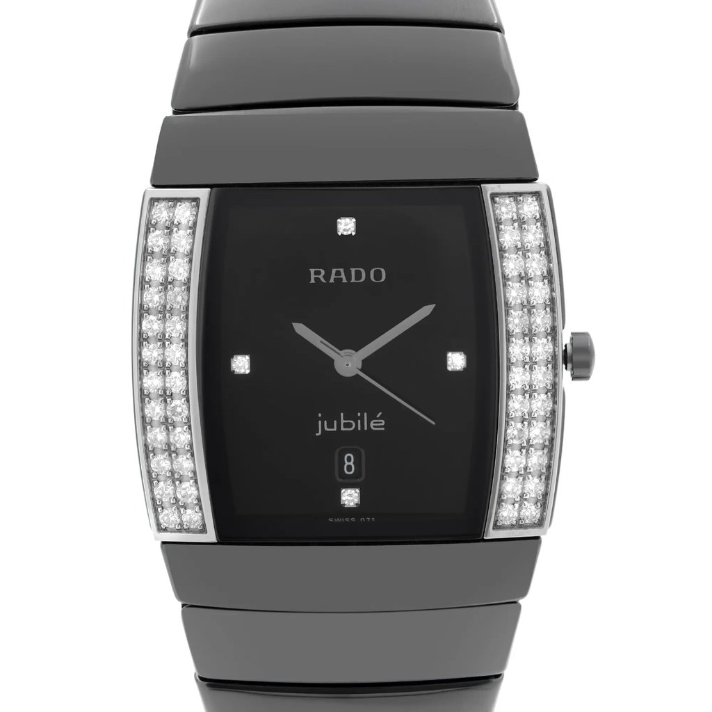 An image of a pre-owned wristwatch, viewed from the front in a close-up shot. The watch face is rectangular with a black background, adorned with diamond accents along the sides. The brand name is visible on the face, and it features silver hour and minute hands. The watch has a polished metallic band.