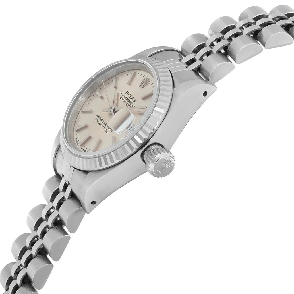 An image of a pre-owned wristwatch shown from a side profile view, highlighting the crown. The watch features a metallic case and a polished bracelet. The angle captures the watch at a slight tilt, emphasizing the fluted bezel and the details on the dial. The photo is taken from a close distance, showcasing the craftsmanship and condition of the timepiece.