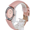 An image of a JOWISSA women's wristwatch positioned at a slight angle, showcasing its round face. The watch has a pink dial with silver hands and is encircled by a decorative bezel with clear stones. The pink strap is partially visible, and the watch is displayed on a clear stand against a white background. The photo is taken from a close distance, highlighting the watch's design and details.
