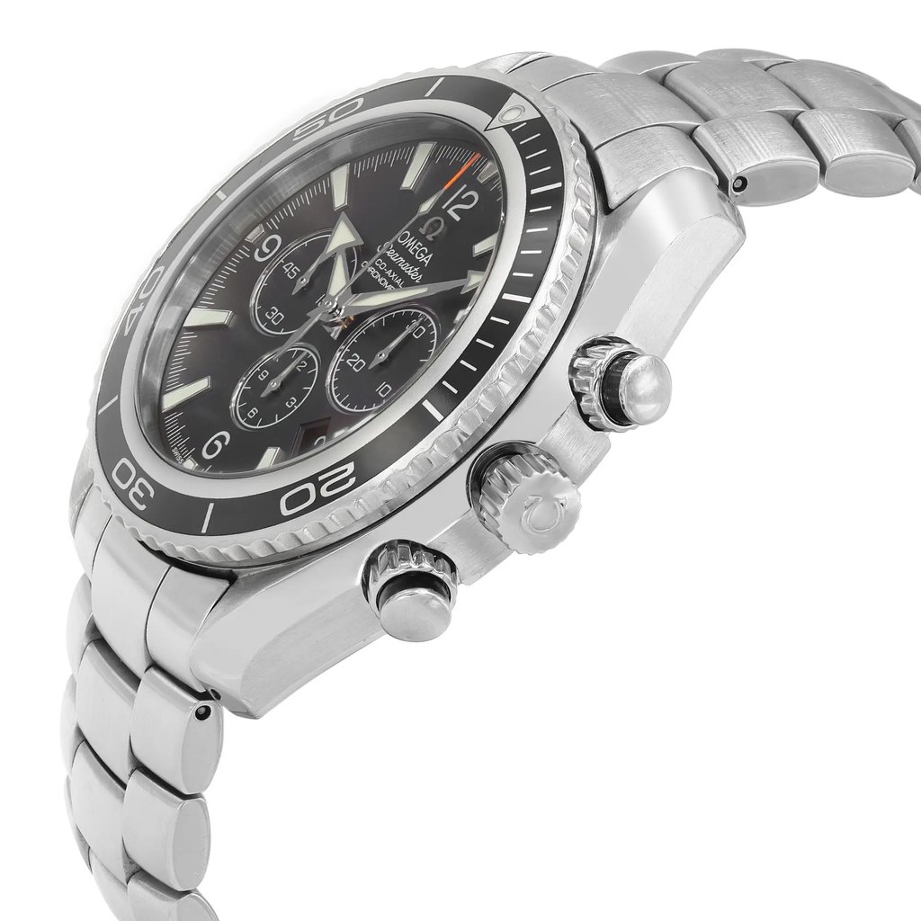 An image of a pre-owned men's OMEGA wristwatch featuring a chronograph, date indicator, and luminous hands. The watch, seen from a side angle, highlights its metallic band and detailed crown with pushers on the right side. The angle showcases the watch face and bezel clearly, emphasizing its sleek design and functionality.