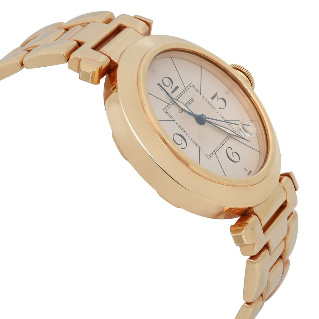 An image of a pre-owned Cartier men's wristwatch, viewed from a slightly elevated angle to the right, showcasing its elegant design. The watch features a round case with a gold-tone finish, a date indicator, and luminous hands. The bracelet is partially visible, with the focus on the watch face displaying Arabic numerals at the 12, 3, 6, and 9 o'clock positions. The image captures the watch from a close distance, highlighting its refined details.