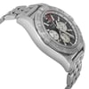 An image of a pre-owned Breitling men's wristwatch in a luxury style, captured from a side profile view opposite the crown. The watch has a round stainless steel case and band, with a gray bezel and a black dial. Visible features include a date indicator, GMT, luminous hands, and a small seconds subdial. The image is taken at a close distance, highlighting the watch's condition, which shows light signs of wear or scratches. The angle provides a clear view of the watch's side contours and bracelet links.