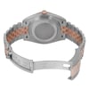 An image of a pre-owned men's Rolex wristwatch viewed from the back. The watch is positioned at a slight angle, showcasing the closed clasp and the stainless steel and rose gold bracelet. The focus is on the back of the watch case, highlighting the brand's engraved details on the clasp. The image is taken from a close distance to capture the intricate design elements.