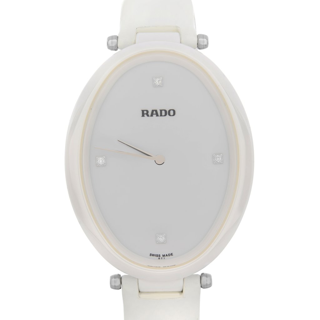 An image of a wristwatch taken from a front close-up angle, focusing on the watch face. The watch features an oval shape with a minimalistic design, showcasing a white dial with simple hour markers and sleek hands. The brand name is visible on the dial. The condition is noted as new with defects.