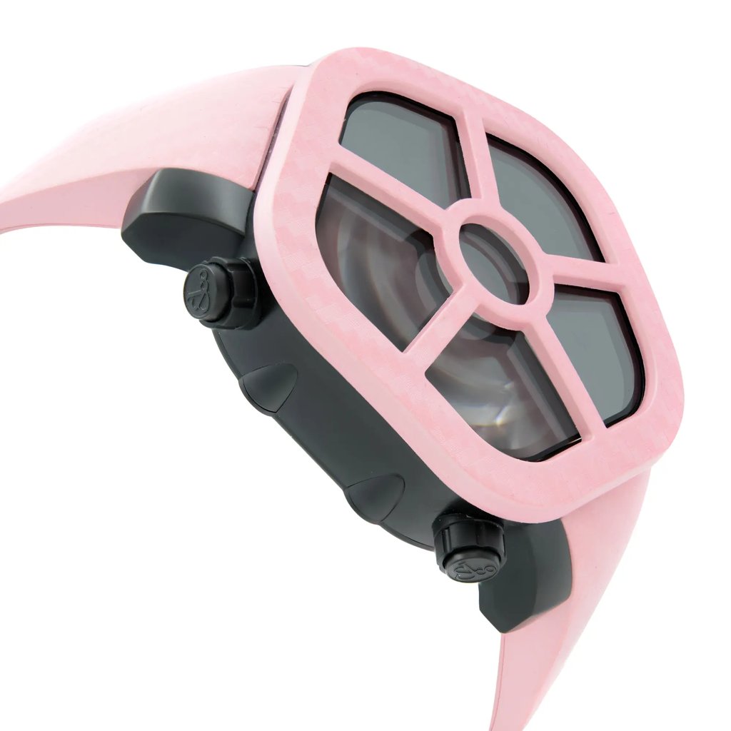 An image of a wristwatch shown from the side profile view, opposite the crown. The watch has a distinctive design with a pink case and a black inner frame. The angle captures the watch at a close distance, highlighting its unique geometric structure and color contrast between the pink and black elements. The watch is a display model, emphasizing its new and pristine condition.