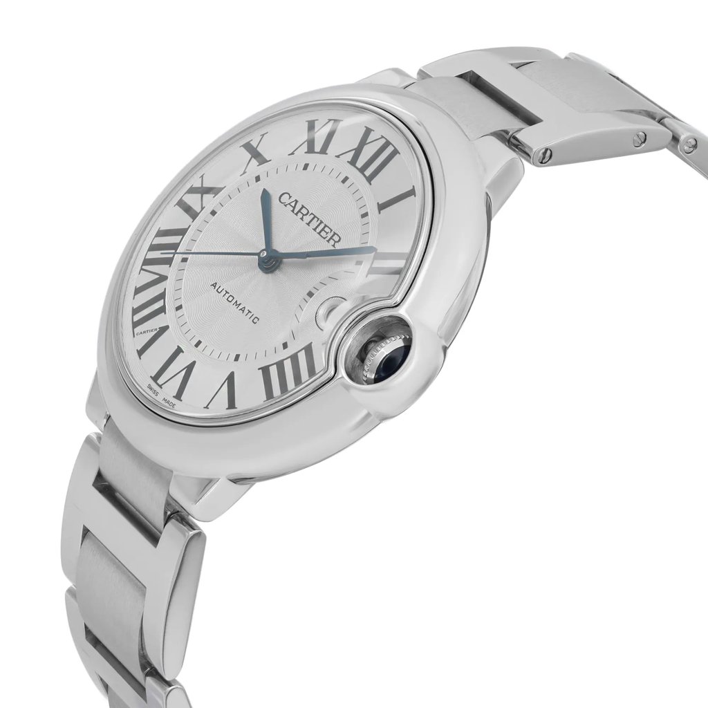 An image of a pre-owned wristwatch viewed from a side profile, showcasing the crown prominently. The watch face features Roman numerals and sleek hands, with the brand name visible. The angle highlights the elegant, metallic bracelet and the curvature of the watch case. The photograph is taken at a close distance, emphasizing the details and craftsmanship.