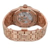 An image of a pre-owned men's Audemars Piguet wristwatch, viewed from the back at a slight angle. The watch features a rose gold case with an octagonal shape and an exhibition caseback, revealing the intricate internal mechanism. The band, also in rose gold, is equipped with a double-locking fold-over clasp. The image shows the watch positioned upright with the clasp closed, highlighting the brand's logo. The condition is classified as good, and the watch includes features like luminous hands.