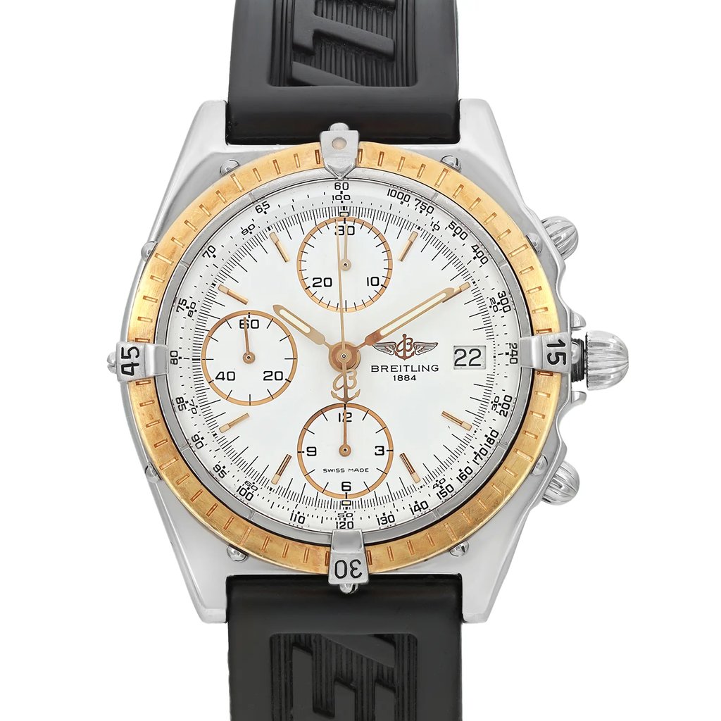 An image of a pre-owned Breitling men's wristwatch in a casual style, shown in a front close-up view with the watch face in focus. The watch features a white dial with a gold bezel and stick indexes, enclosed in a round stainless steel case. Minor nicks are visible on the bezel, indicating previous use. The black rubber band displays signs of wear. The image is taken from a straight-on angle, capturing the entire face and a portion of the strap, 