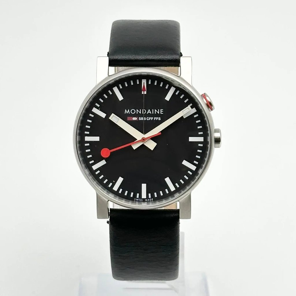 An image of a Wristwatch by Mondaine. This Pre Owned item is designed for Men, featuring a Casual,Classic,Dress/Formal style. It has a Quartz movement and an Analog display with a Black dial color. The indices include 12-Hour Dial,Non-Numeric Hour Marks,Stick Indexes. The band is made of Leather and the case is made of Stainless Steel. The watch has a Round shape with a case size of 40 mm and a case thickness of 12 mm.