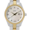 An image of a wristwatch taken from the front in a close-up shot, focusing on the watch face. The watch features a gold and silver-toned case and bracelet. The dial is adorned with diamond-like hour markers and has a date display at the 3 o'clock position. The brand name is visible just below the 12 o'clock marker.