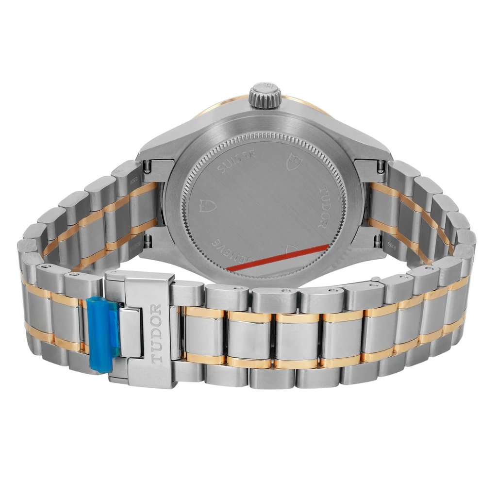 An image of a wristwatch viewed from the back, showcasing the closed clasp. The watch features a stainless steel and gold-tone bracelet. It is positioned at a slight angle, highlighting the unworn condition and the brand name on the clasp. The image is taken from a close distance, focusing on the details of the bracelet links and the case back.