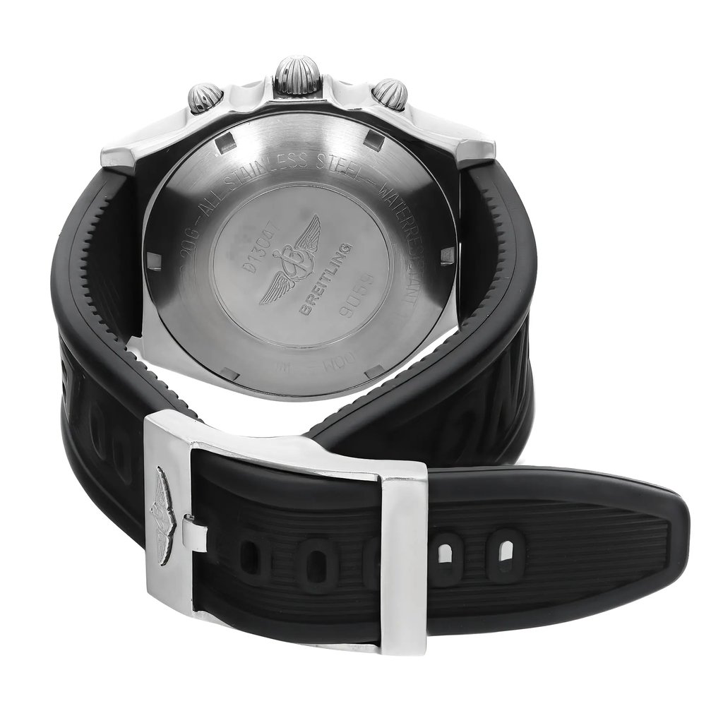 An image of a pre-owned Breitling men's wristwatch viewed from the back, showcasing the stainless steel screwback case with the brand's logo and text. The round shape of the case is evident, and the black rubber band is visible with a buckle closure. The watch is positioned with the caseback facing upwards and the band looping downwards, shown from a top-down angle with a close-up perspective.