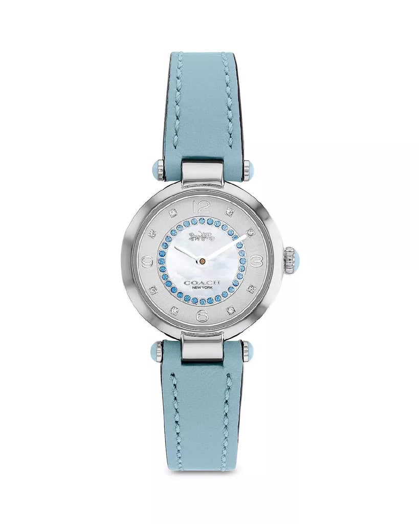 An image of a Wristwatch by Coach. This Pre Owned item is designed for Women, featuring a Dress/Formal style. It has a Quartz movement and an Analog display with a White dial color. The indices include 12-Hour Dial,Arabic Numerals. The band is made of Leather and the case is made of Stainless Steel. The watch has a Round shape with a case size of 26 mm and a case thickness of 8 mm.
