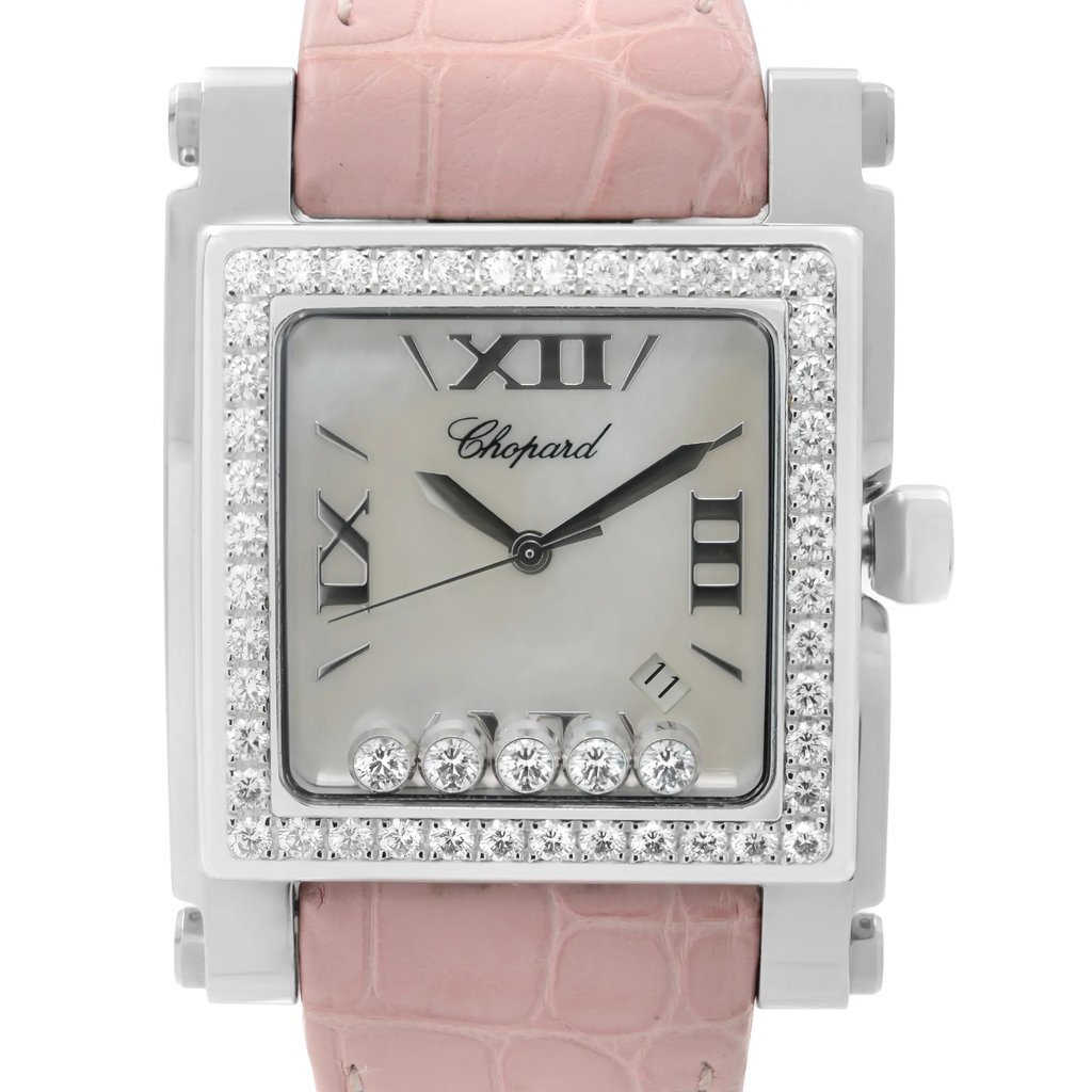 An image of a pre-owned wristwatch taken from a front close-up angle, focusing on the watch face. The watch features a square silver bezel embellished with small diamonds and a pink strap with a textured pattern. The face has a pearlescent background with Roman numerals and a brand name inscribed. Five larger diamonds are embedded at the bottom of the face.