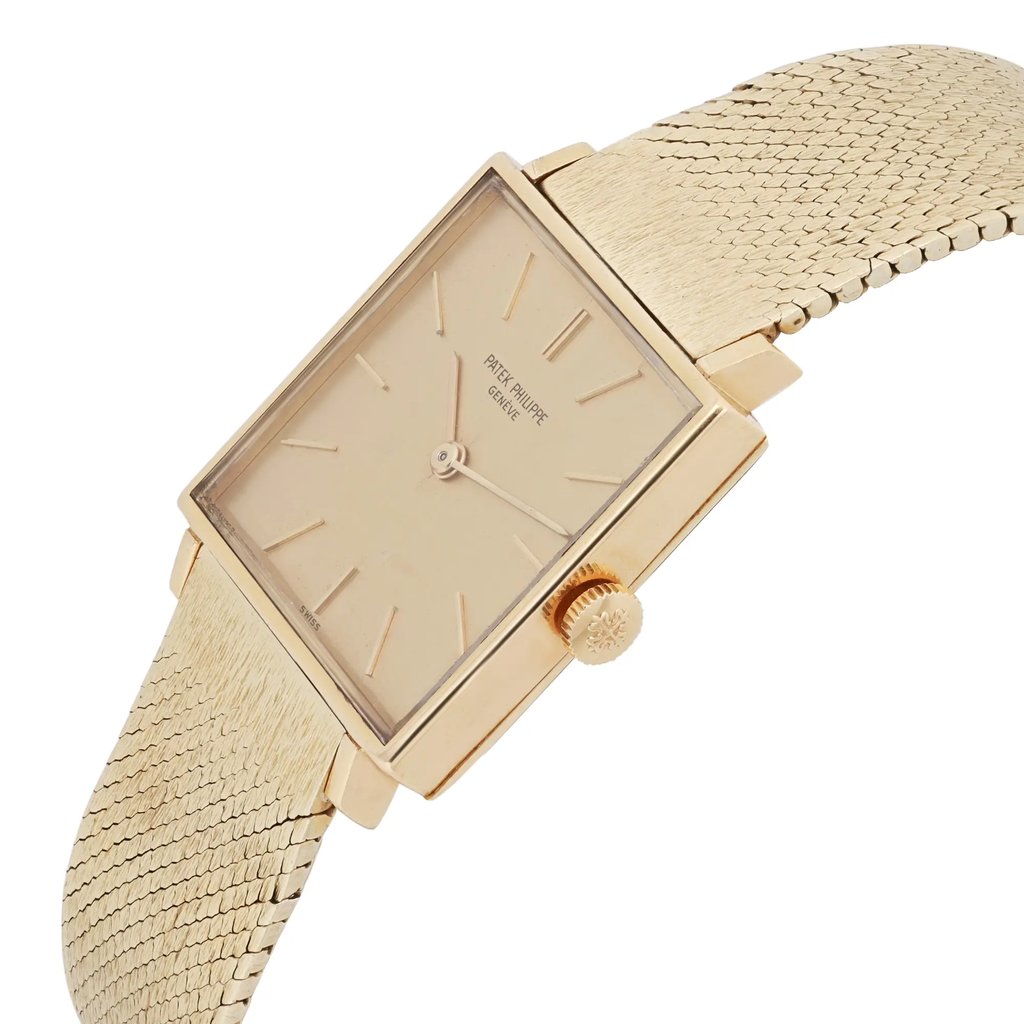 An image of a pre-owned Patek Philippe wristwatch, designed for unisex adults. The watch is positioned at a slight angle, showcasing its rectangular face and the textured band. The crown is prominently visible on the right side. The watch is photographed up close, highlighting its elegant design and detailing.