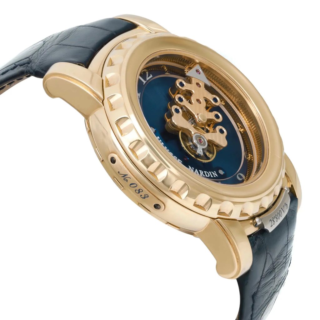 An image of a pre-owned wristwatch viewed from the side profile, opposite the crown. The watch features a gold-toned case with intricate detailing, showcasing a visible mechanical movement on a deep blue dial. The black leather strap adds elegance, and the angle highlights the watch's craftsmanship and design intricacies. The watch is positioned at a close distance, emphasizing its luxurious appearance.