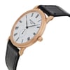 An image of a pre-owned wristwatch shown from a side profile view. The watch features a round, white dial with Roman numerals and black hands. The gold crown is prominently displayed on the right side. The black leather strap is visible, and the watch is positioned at a slight angle, showcasing its elegant design.